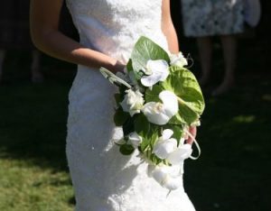 woman wearing bridal gown holding a bouquet of flowers walking down the aisle