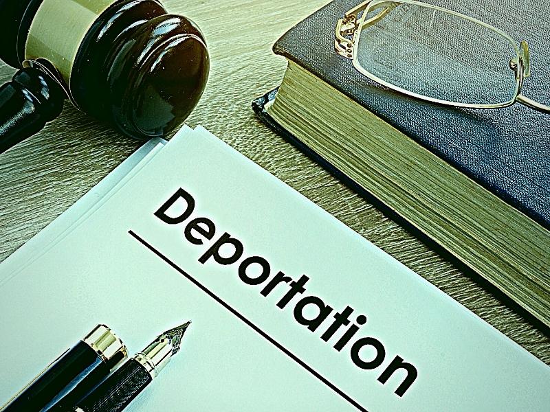 Deportation and other documents on a desk.