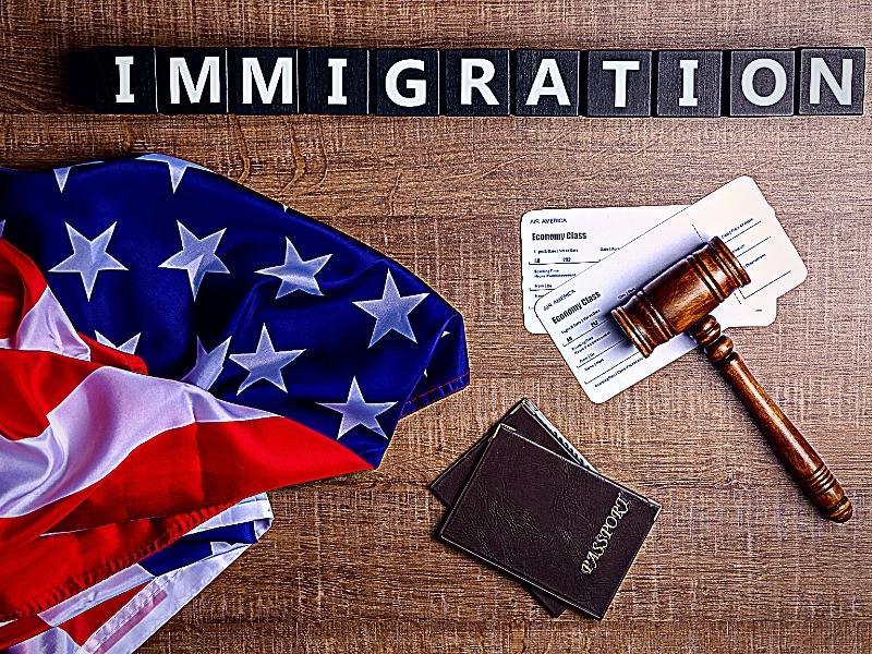 Cubes with word IMMIGRATION, judge's gavel and American flag on table