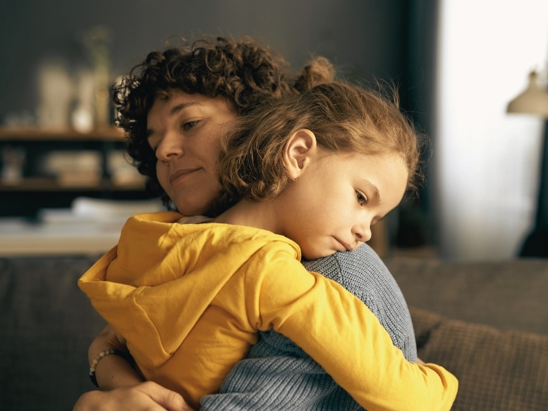 Young mom embracing and calming her child while he in bad mood or upset feelings. Concept of Requirements for Traveling on DACA