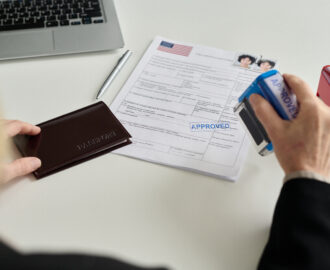 Close up of immigration office worker approving visa application. Adjustment of Status vs. Consular Processing