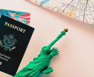 United States passport, a permanent resident card, a map and Statue of Liberty flat lay on the gradient surface. work in the U.S. while my green card application is pending