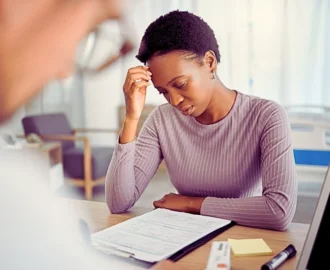 Concerned woman looking at paperwork in medical office. Immigration medical exam is delayed